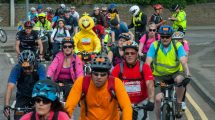 London to Brighton cycling event. Crowd of cyclists with yellow Big Bird character in the middle. Police giving cyclist ticket.